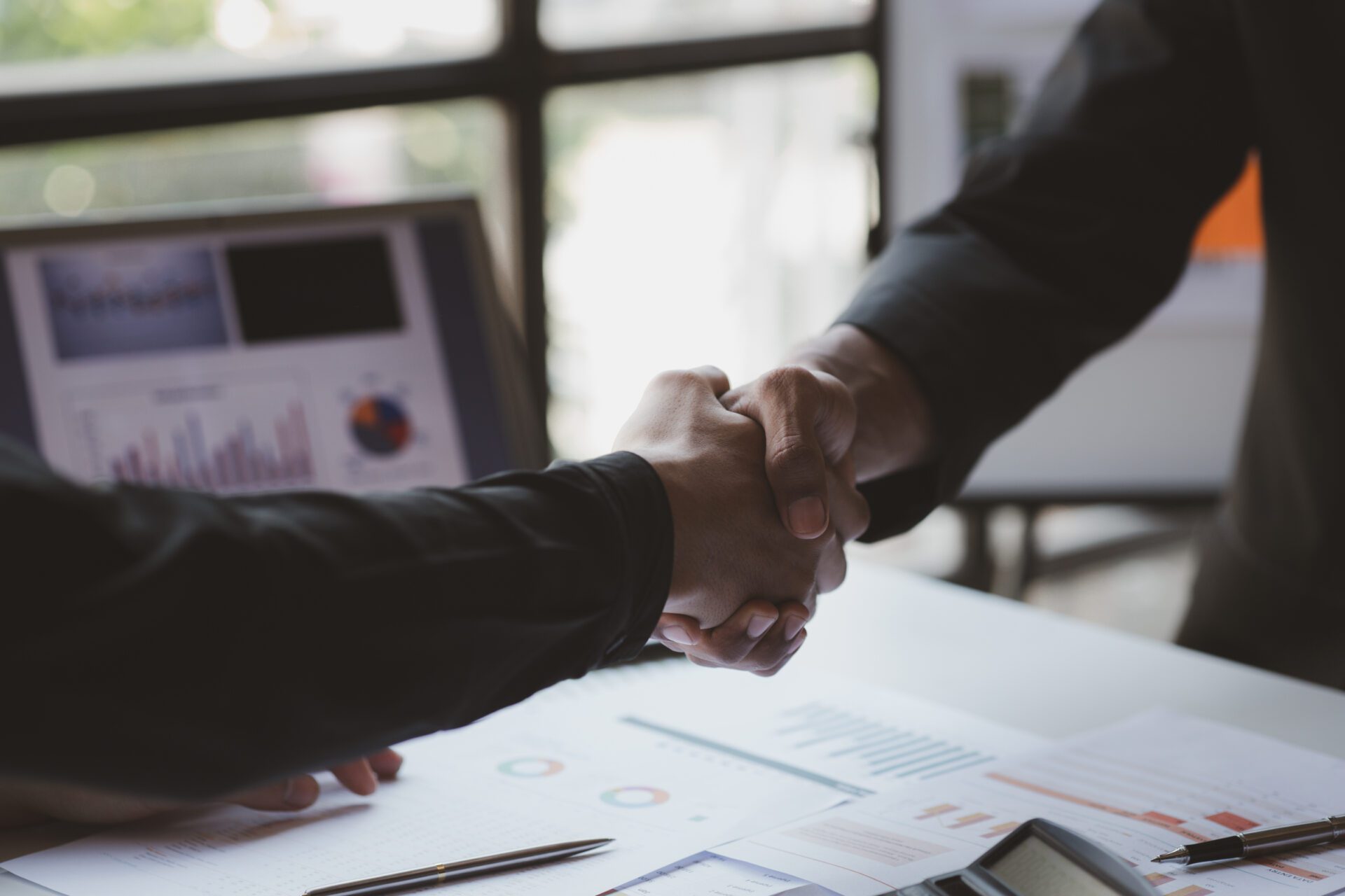 Business investor group holding hands, Two businessmen are agreeing on business together and shaking hands after a successful negotiation. Handshaking is a Western greeting or congratulation.